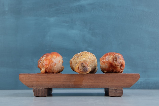 Foto gratuita una tavola di legno con carne di cosce di pollo fritte.