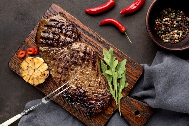 Wooden board with grilled meat and seasoning