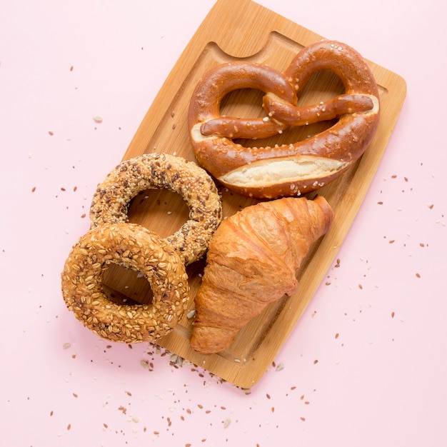 Wooden board with pretzel and croissant