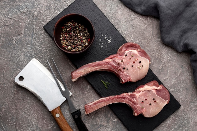 Wooden board with raw meat and ingredients