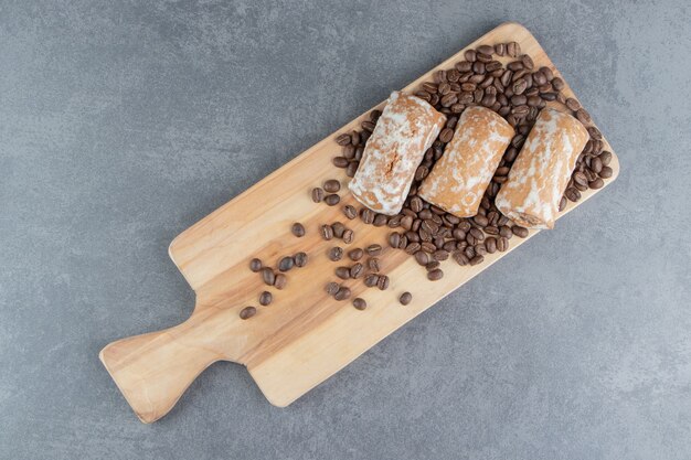 A wooden board with sweet gingerbread and coffee beans 