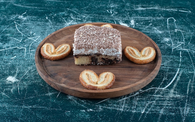 Una tavola di legno con pasticceria dolce su sfondo blu. foto di alta qualità