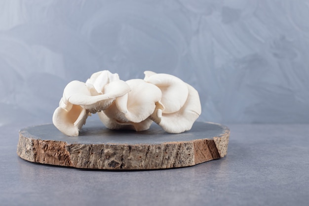Деревянная доска с белыми грибами.
