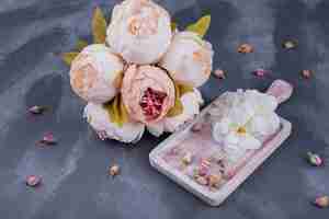 Free photo wooden board with withered rose on dark.