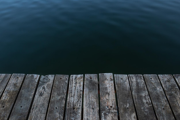 Wooden boards and water masonry on the lake closeup