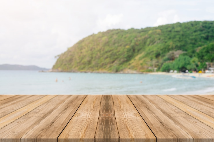 Free Photo wooden boards with blurred beach background