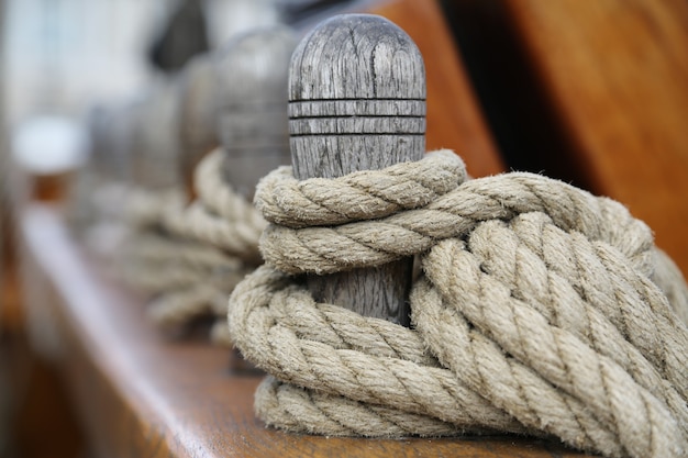 Free photo wooden bollard with a tied rope