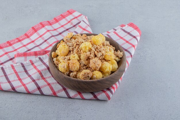 A wooden bowl of delicious healthy cereals on a tablecloth . High quality photo