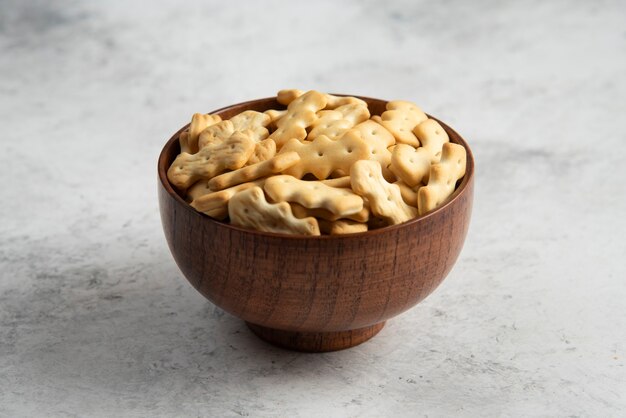 A wooden bowl full of delicious crackers .