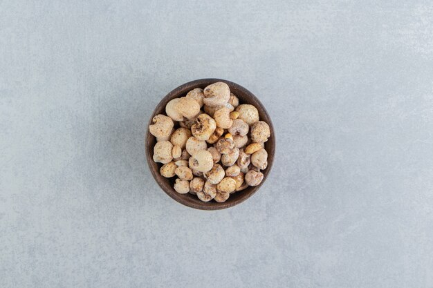 A wooden bowl full of delicious round food .