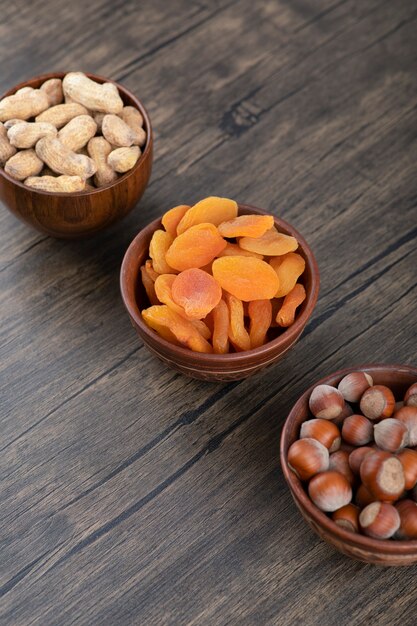 A wooden bowl full of dried apricot fruits with healthy nuts. 