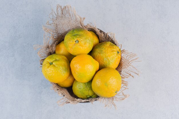 Wooden bowl full of fresh tangerines. 