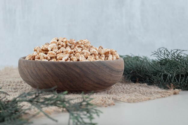 A wooden bowl full of healthy cereals .