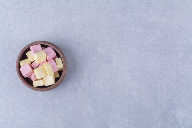 A wooden bowl full of pink sweet confectionery Pastila . 