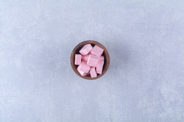 A wooden bowl full of pink sweet confectionery Pastila . 