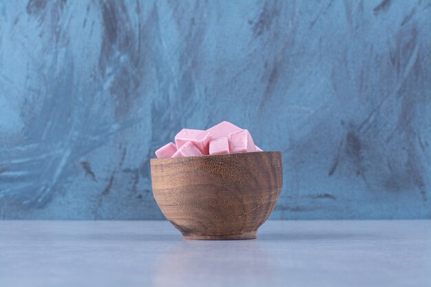 A wooden bowl full of pink sweet confectionery Pastila . 