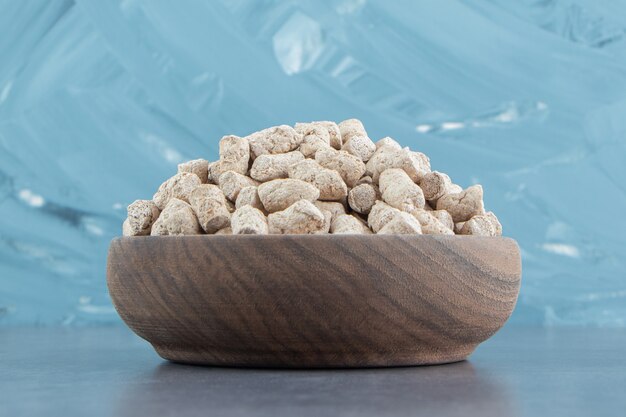 A wooden bowl full of rye crispy cereals .