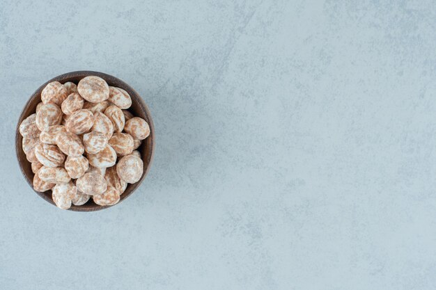 A wooden bowl full of sweet delicious gingerbread on white surface