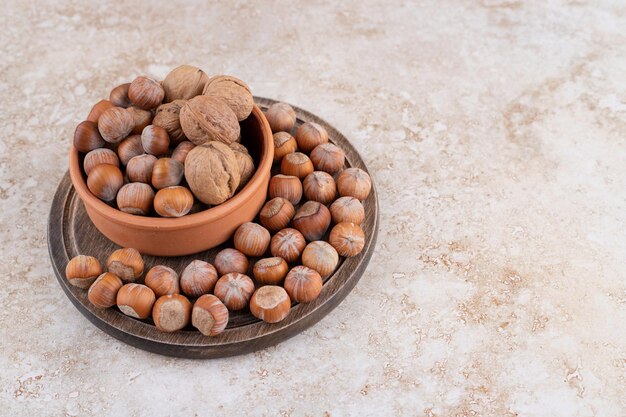 A wooden bowl of macadamia nuts and walnuts