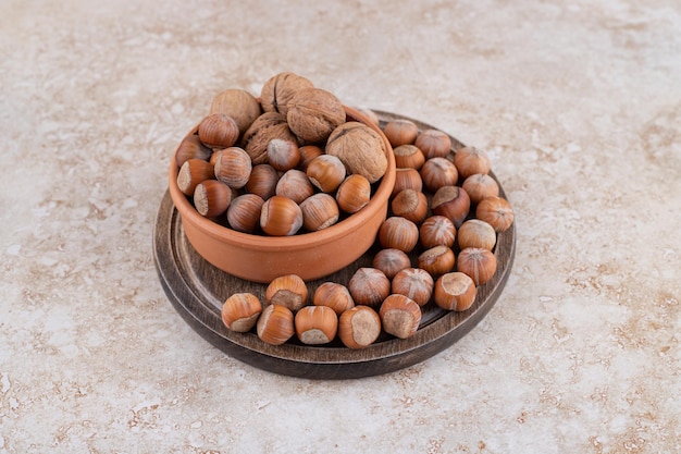 A wooden bowl of macadamia nuts and walnuts