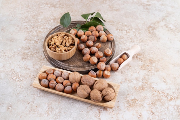 A wooden bowl of macadamia nuts and walnuts.