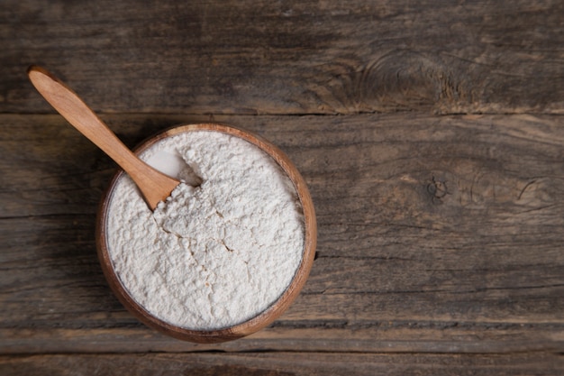 Free photo wooden bowl of organic flour placed on wooden surface. high quality photo