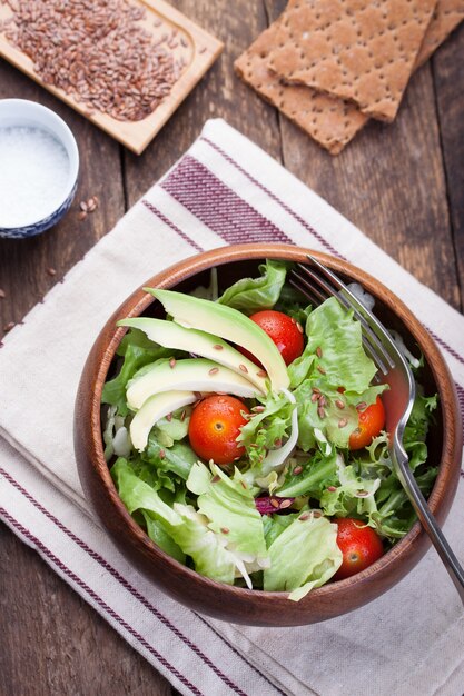 Wooden bowl with salad seen from above