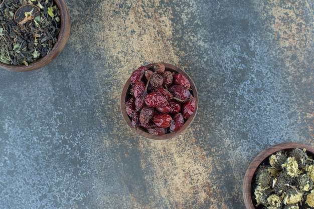 Wooden bowls of dried flowers and rosehips.