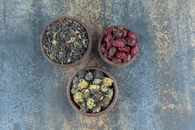 Free photo wooden bowls of dried flowers and rosehips.