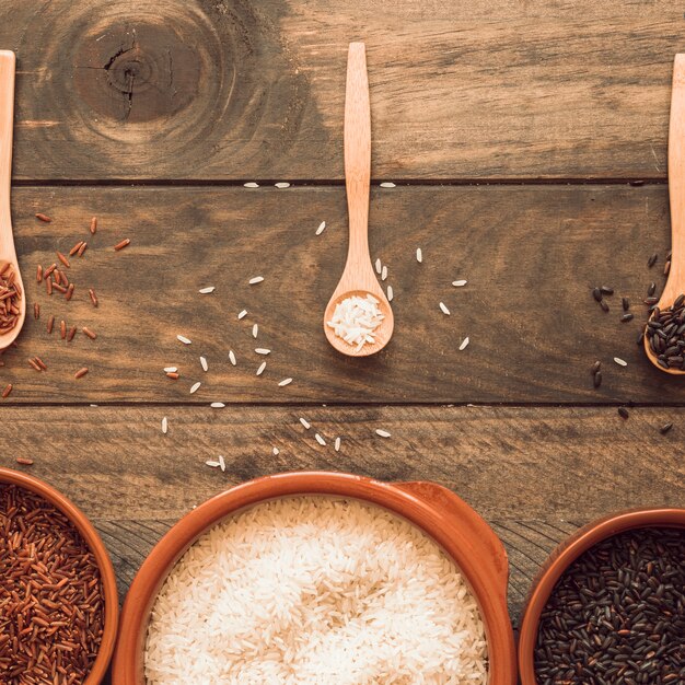 Wooden and bowls with an organic rice grains on wooden table