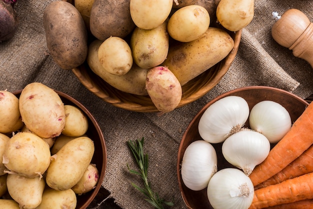 Wooden bowls with potatoes carrot and garlic