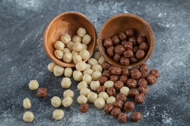 Wooden bowls with sweet corn balls on gray.