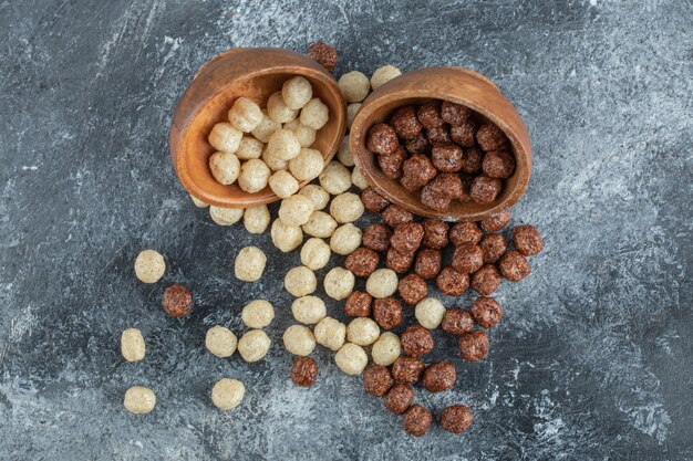 Wooden bowls with sweet corn balls on gray.