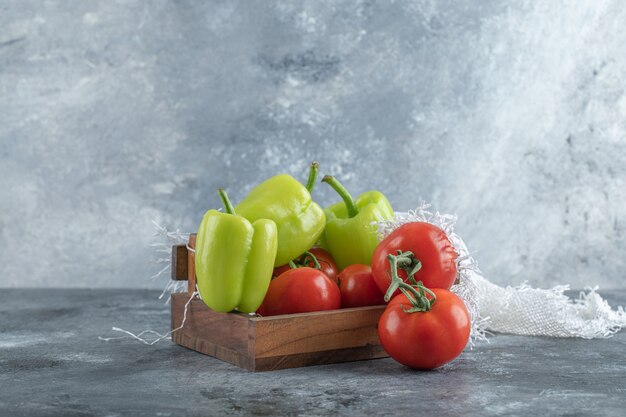 Wooden box of fresh ripe vegetables on marble background