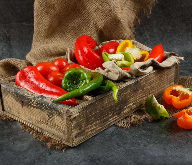 A wooden box full of mixed vegetables.