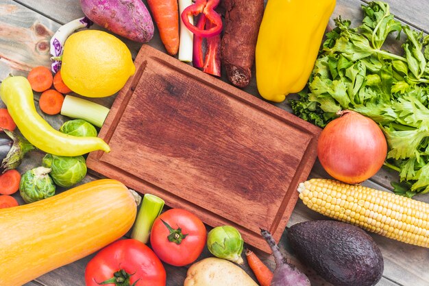 Wooden chopping board surrounded by various raw food