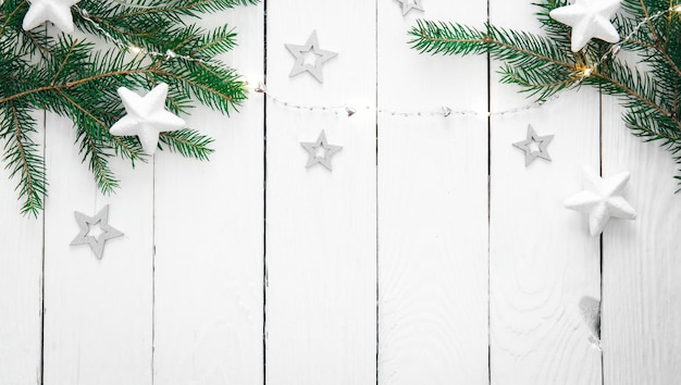 Wooden Christmas background with fir branches garland and decorative stars