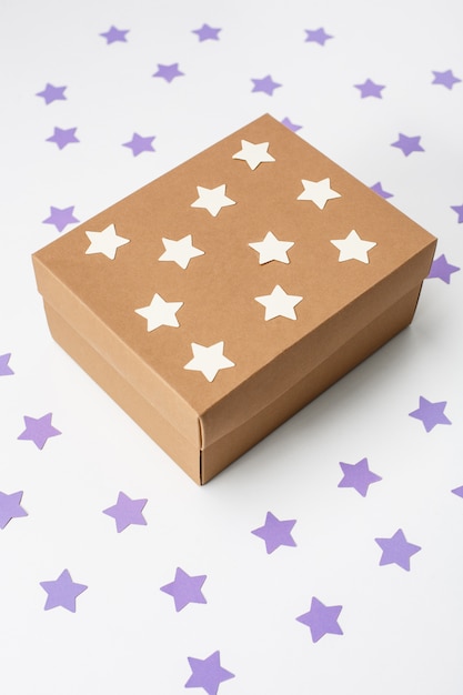 Wooden christmas gift box over white wall with stars