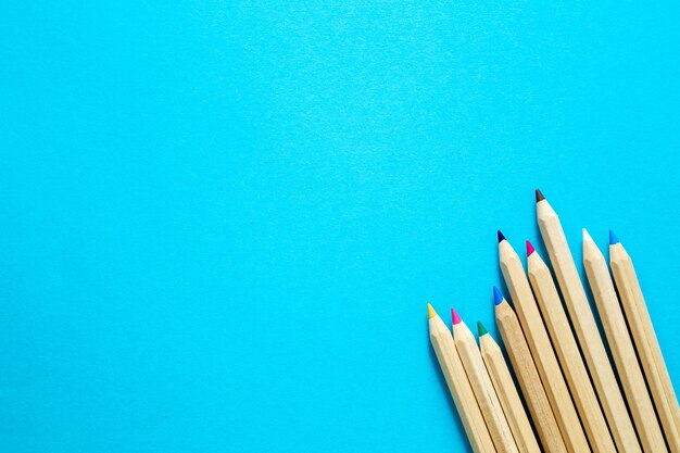Деревянные цветные карандаши на синем фоне