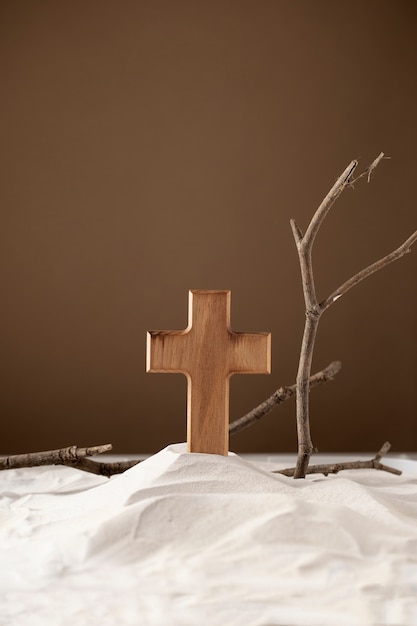 Бесплатное фото Деревянный крест и ветки на песке