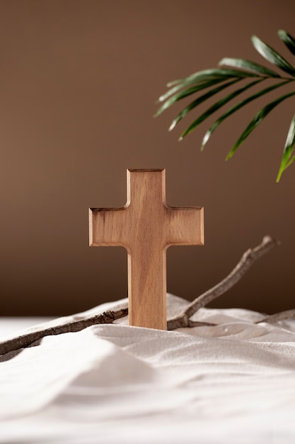 Free photo wooden cross, branches and leaf arrangement