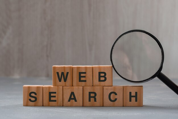 wooden cubes on plaster and magnifying glass