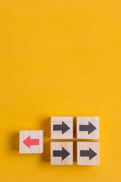 Free photo wooden cubes with arrow on yellow copy space background