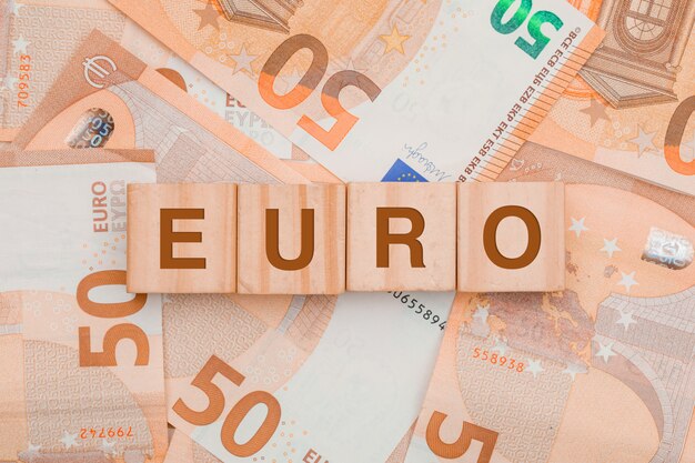  wooden cubes with word euro on banknote table .