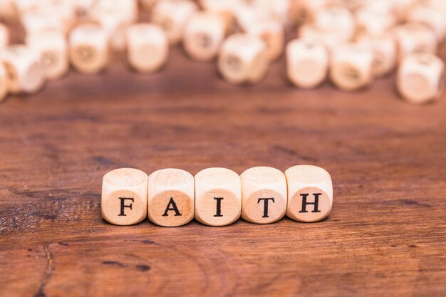 Wooden cubes with word faith on table