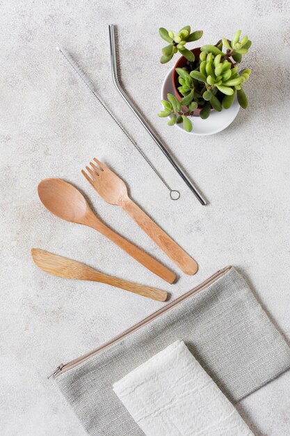 Wooden cutlery on wallet and plant