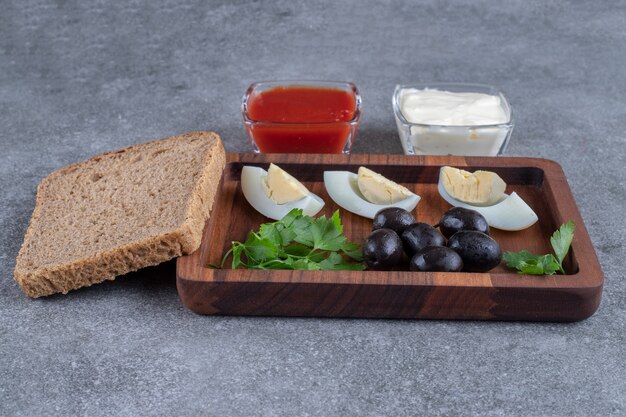 ゆで卵とパンのスライスが入った木製のまな板。高品質の写真