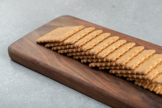 A wooden cutting board with delicious crackers.