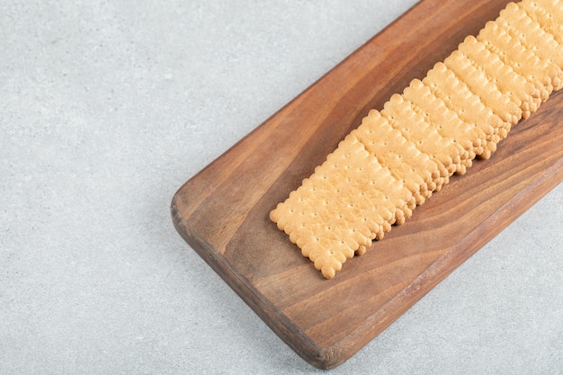 Foto gratuita un tagliere in legno con deliziosi cracker.