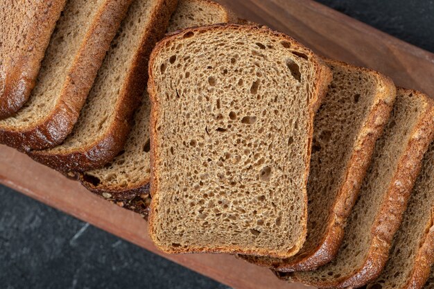 A wooden cutting board with slices of bread.